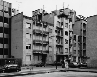 Multiplicity - Mappe, Thomas Struth, Milan, via Emilio Cornalia, 1992 (courtesy Monica De Cardenas), fotografia in bianco e nero.
Il reportage falsamente casuale della nostra città, tradisce uno sguardo d'artista invece preciso e acuto. Palazzi grigi ed edifici, sottofondo visivo nel nostro quotidiano, emergono come ineludibili icone contemporanee