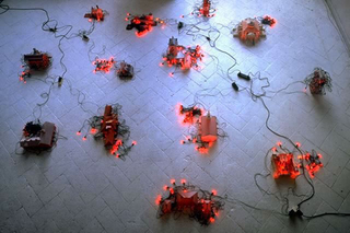 Liliana Moro, Le città, 1995
(The cities)
Paper constructions and intermittent red lights
Studio Casoli, Milano
Foto: Roberto Marossi